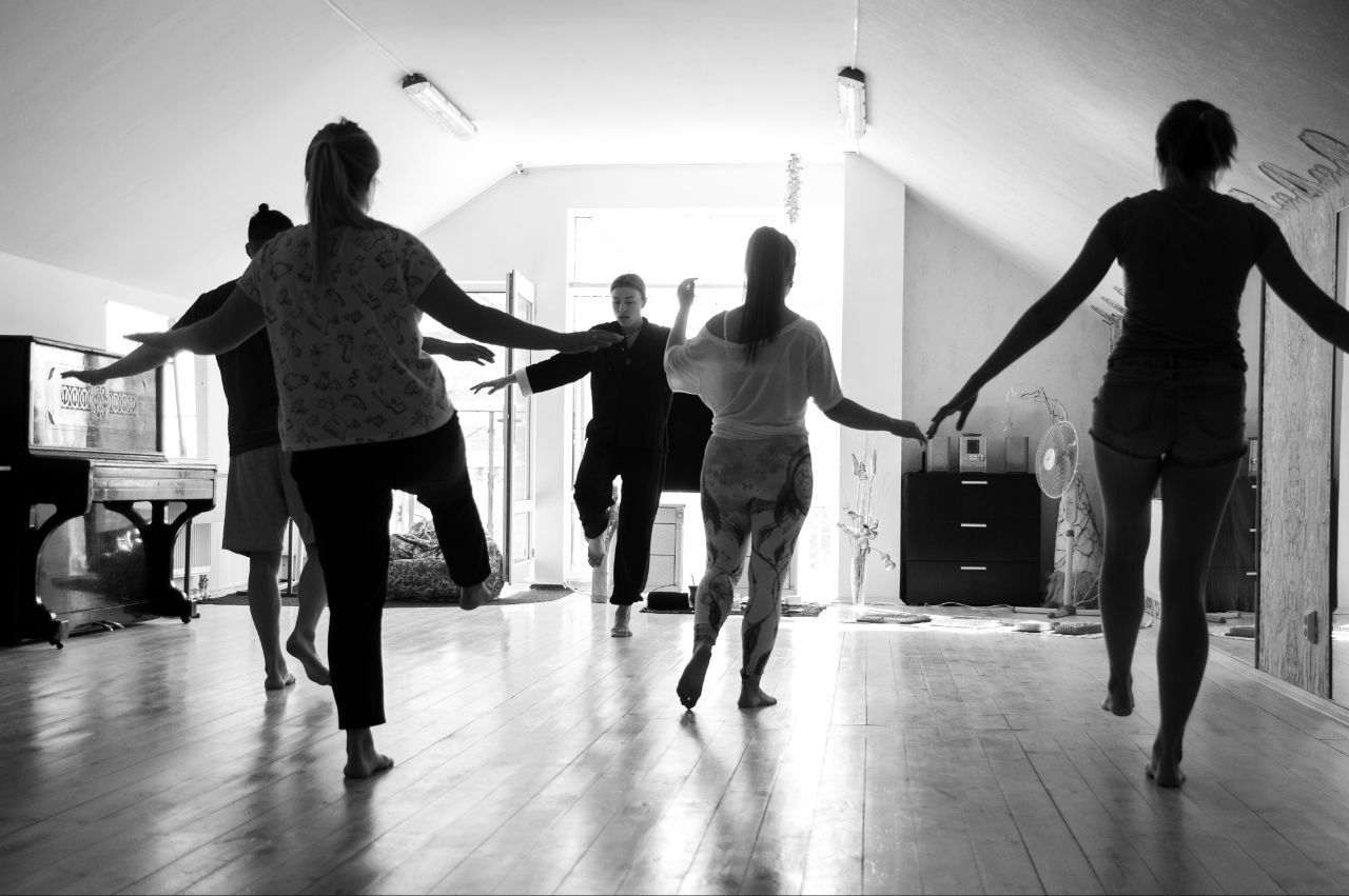 Руки ведущей поддерживают участницу практики